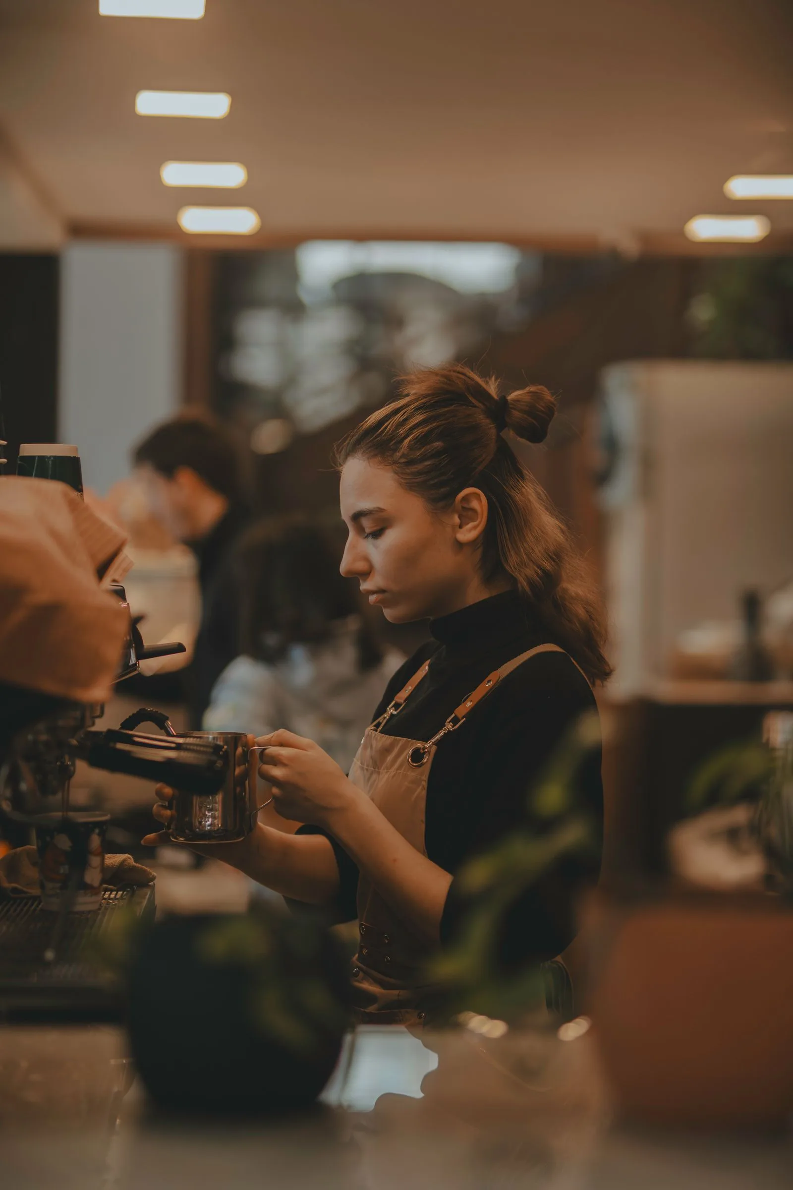 Barista preparando una bebida en la barra de una cafetería